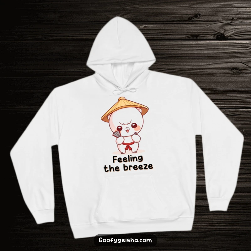 Funny hoodie features a cute Kawaii character in a Japanese hat, fanning itself, offering warmth and style.